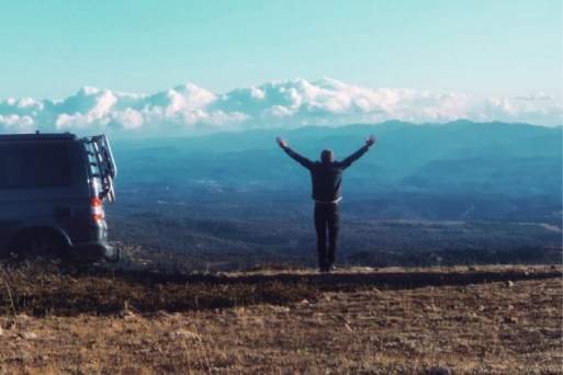 Man raising arms over head in nature scene